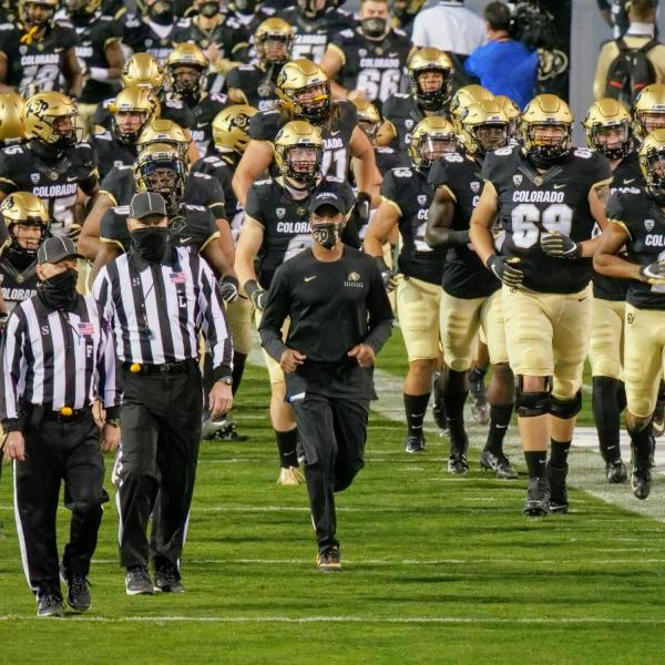 Colorado Head Coach Karl Dorrell leads the Buffs onto the field at the start of the game against UCLA. (Photo by Glenn Asakawa/University of Colorado)