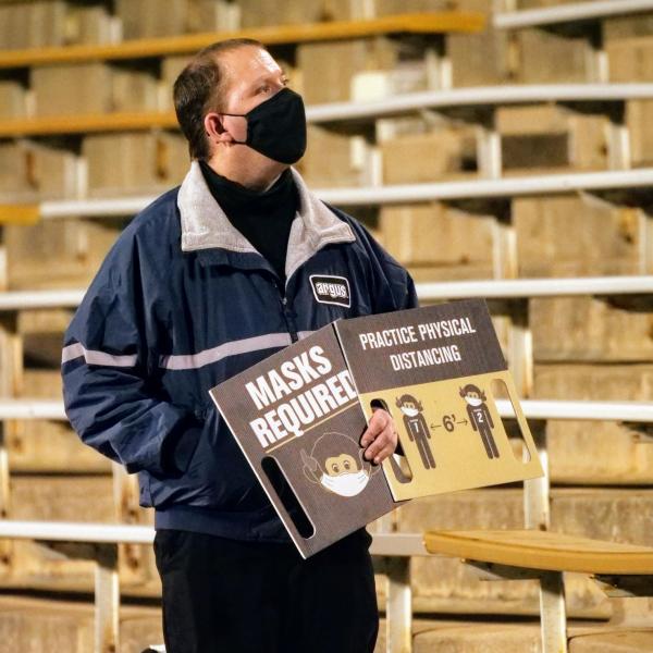 Workers keep safety signs visible to the crowd at the Colorado-UCLA football game on Saturday, Nov. 7, 2020. (Photo by Glenn Asakawa/University of Colorado)