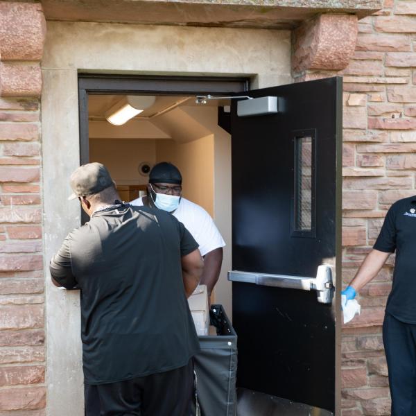Scott Loyd, of Aurora, left, helps his son, DeVonte, move into Aden Hall. DeVonte is a first year aerospace engineering major. Parents and first year students at CU Boulder move into the residence halls on Monday, August 17, 2020. They adhered to facial covering and social distancing policies. (Photo by Glenn Asakawa/University of Colorado)
