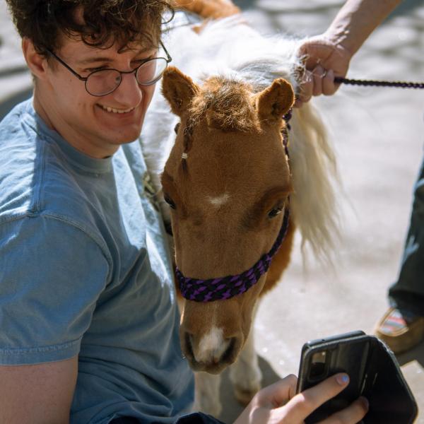 Forrest Kennedy, a junior, takes a selfie with Love Bug, an 8-year-old American miniature horse. (Zach Ornitz/University of Colorado)