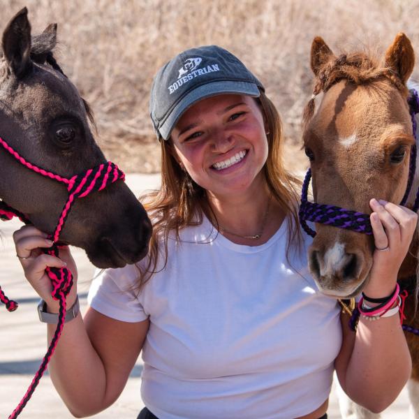 Dani Dresdner, a junior, poses with mini horses Happy Times (left) and Love Bug (right). (Zach Ornitz/University of Colorado)