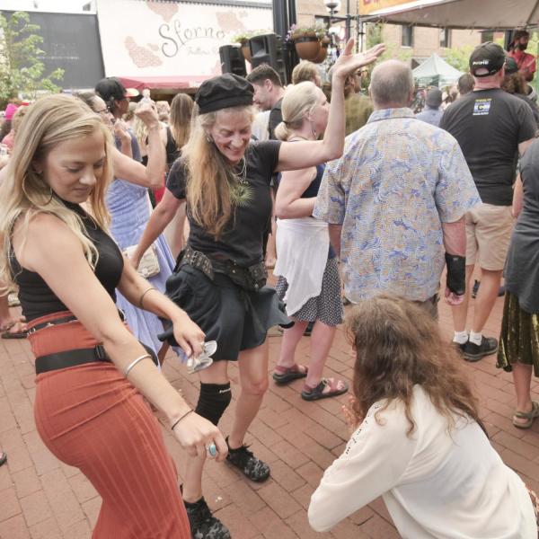 People in the crowd dance to the music at Bands on the Bricks on Pearl Street