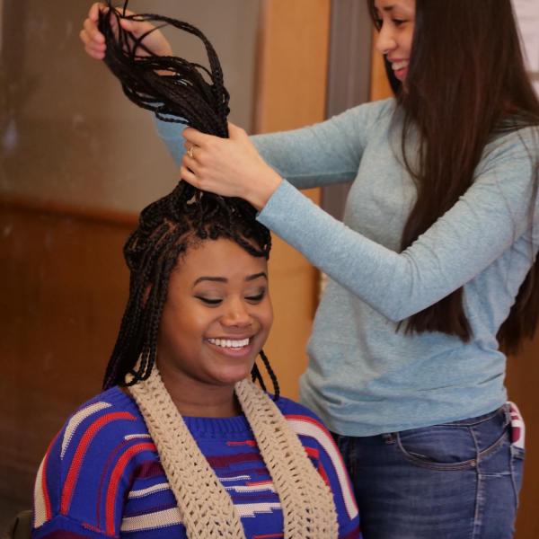 Lluvia Macias, neuroscientist science major, adjusts the hair of Sarah Gilliard, ODECE student and strategic programs coordinator. Photo by Casey A. Cass.