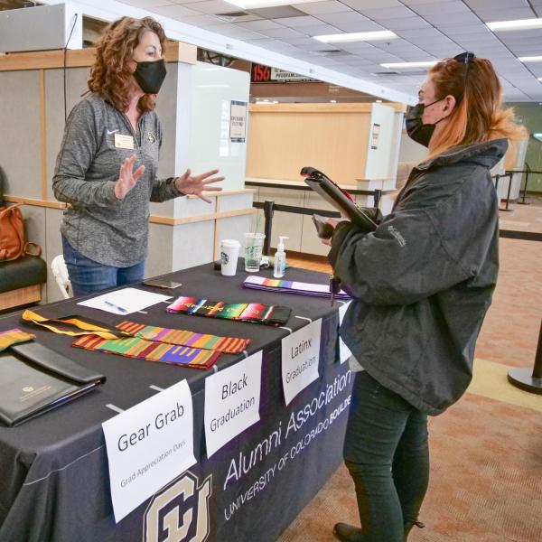 Students sign the Class of 2021 banner and pick up regalia at the 2021 Gear Grab event. (Photo by Casey Cass/University of Colorado)