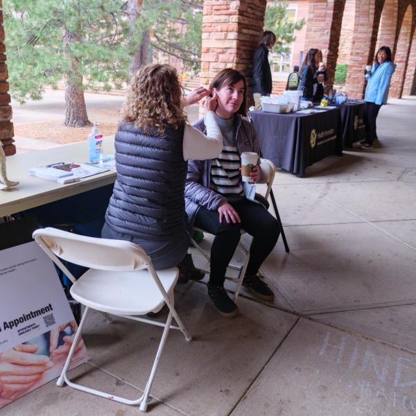 Visitors to the acupuncture table were given a sample of ear seeds placed on the ear's pressure points during the Health Hut event. (Photo by Glenn Asakawa/University of Colorado)