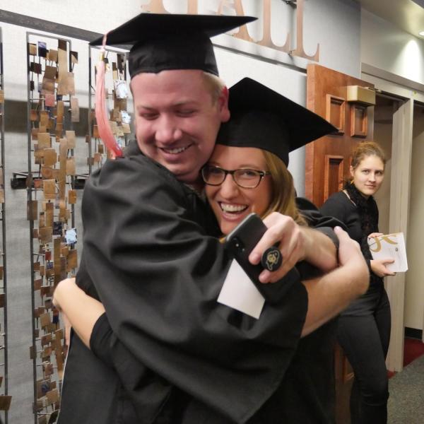 Graduates Lane Mellot and Caroline Vickstrom congratulate one another before the College of Music ceremony