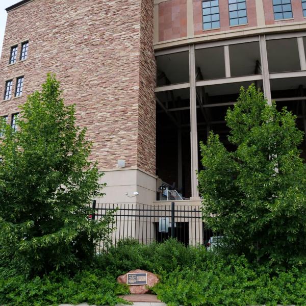 A plaque honoring the late Betty Hoover and her twins sister, Peggy Coppom, sits between "twin" trees planted along the Buff Walk on the east side of Folsom Field. (Photo by Glenn Asakawa/University of Colorado)