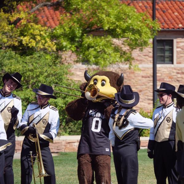 Chip plays with the Golden Buff Marching Band during the official ribbon-cutting and opening ceremony of the Warner Imig Music building expansion. (Photo by Glenn Asakawa/University of Colorado)