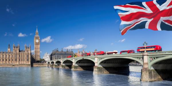 Stock image of double decker red buses on a bridge with Big Ben clock tower in the background