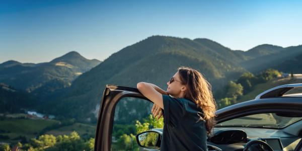 person traveling by car in the mountains during summer vacation