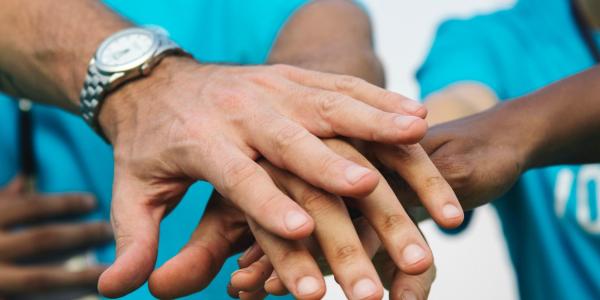 Circle of people put their hands together