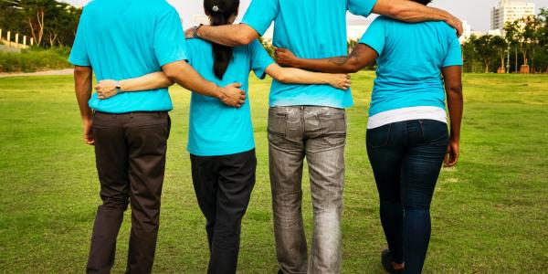 Group of in teal shirts walking arm in arm