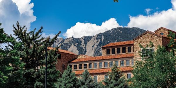 campus building with Flatirons in the background