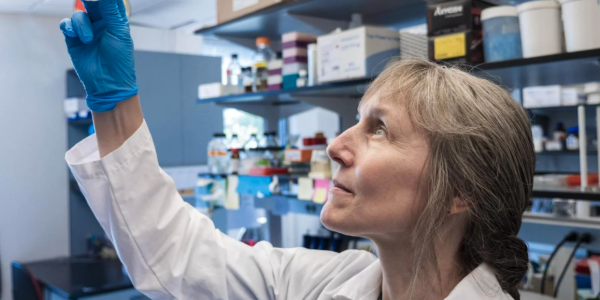 Professor Corrie Detweiler holding up a lab sample to the light