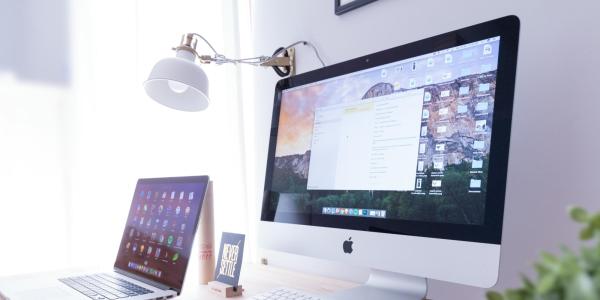 Laptop, desktop computer and phone on a desk