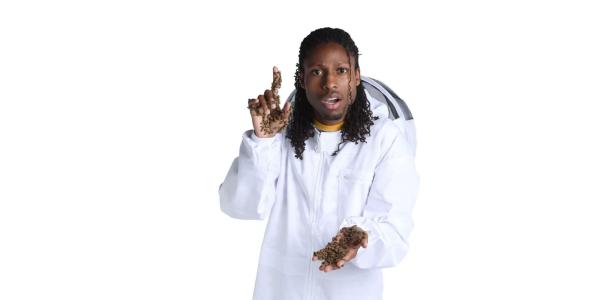 Samuel Ramsey, in a white lab coat, is covered with bees.