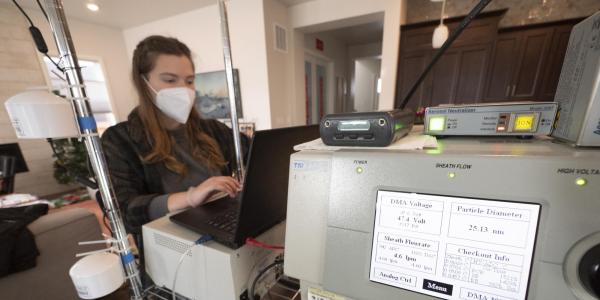 Woman works at large piece of scientific equipment