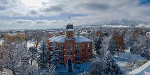 Aerial photo of Old Main building with the Flatirons in the background