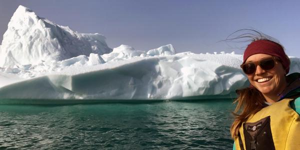 Graduate student Sarah Crump poses in front of an Arctic glacier