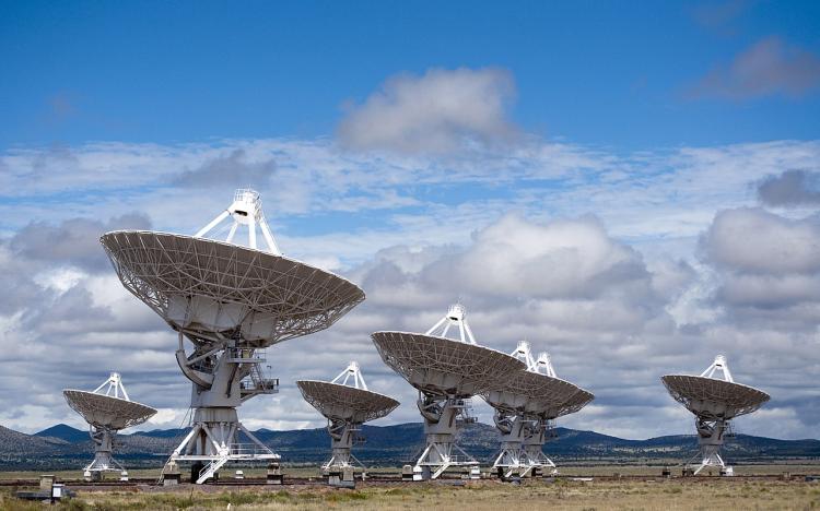 Several dish antennae in a field.