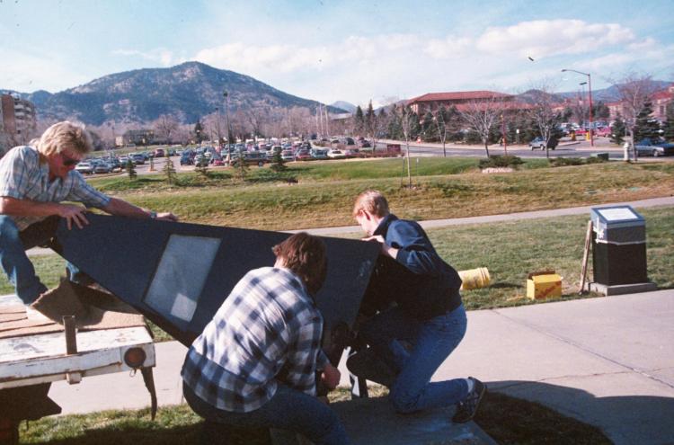 Tom Ayres, left, a senior research associate at the Center for Astrophysics and Space Astronomy (CASA) at CU Boulder, helps to lift the central pyramid for the model solar system into place in 1987.