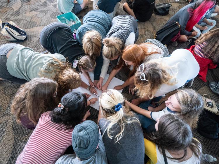 CMCI students huddle in a circle at College Day