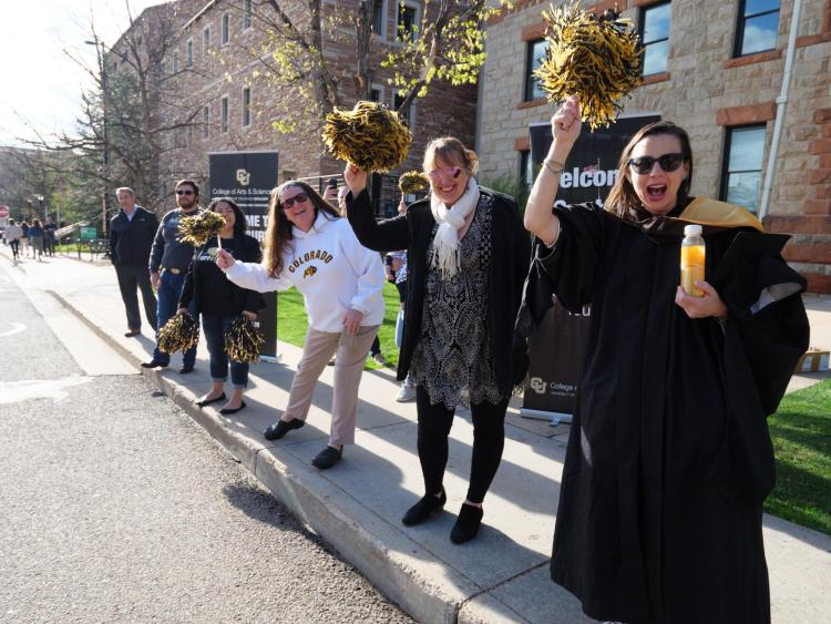 Students, parents, families, faculty, staff, guests and leadership cheer on 2022 graduates as they process to Folsom Field