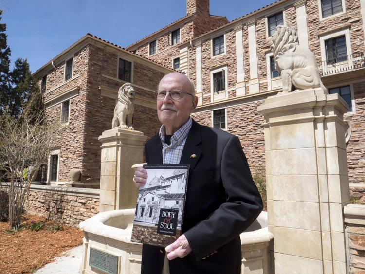 Campus Architect Emeritus Bill Deno poses for photo with Body & Soul book