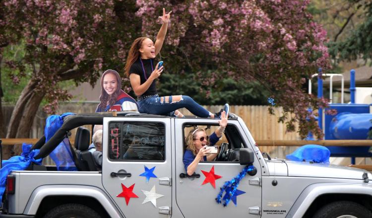 Student leans out of car sunroof to celebrate