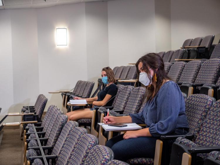 students physically distance in large lecture hall