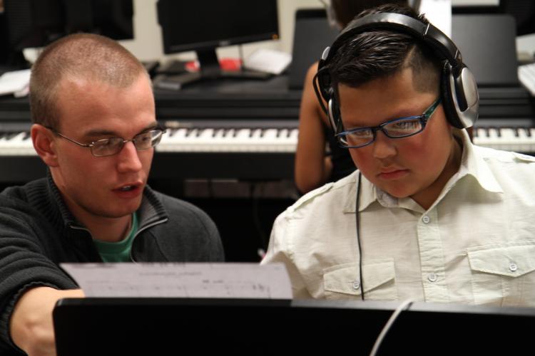 CU student teacher helps elementary student during Piano for Dreamers class