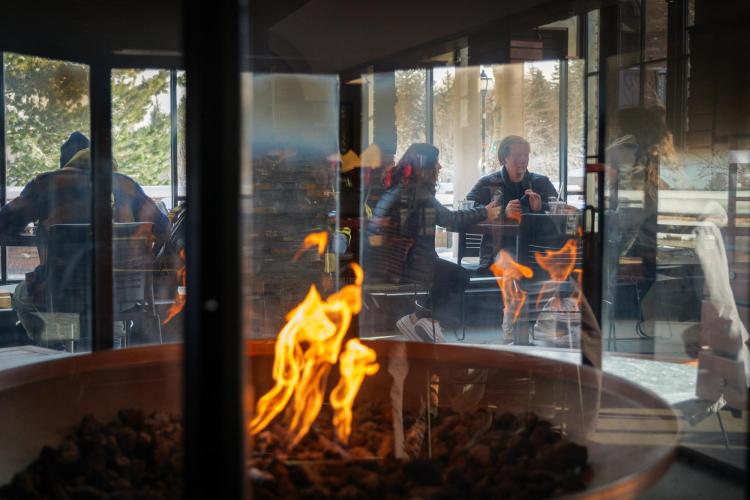 Students sit inside near a fire in the WeatherTech Cafe