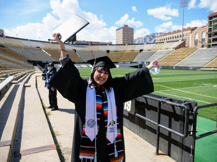 Valeria Ayala Alonso celebrates after getting her photo taken at Folsom Field during Grad Appreciation Days events