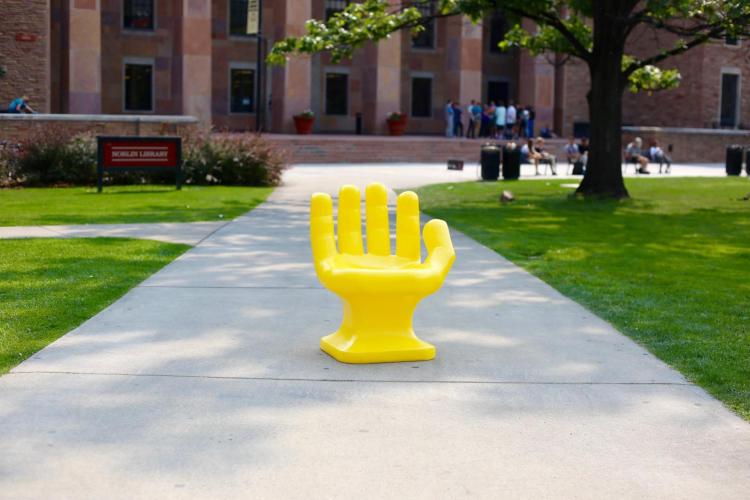 Bright yellow hand sculpture on campus