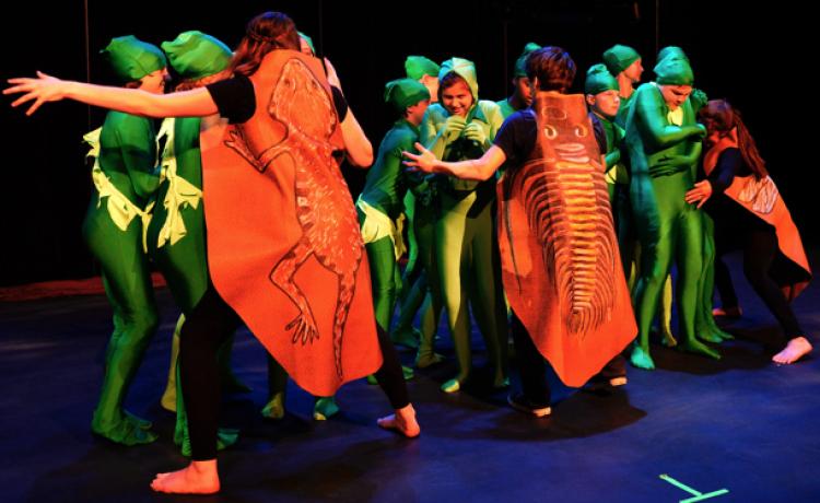 Children in costumes perform on stage