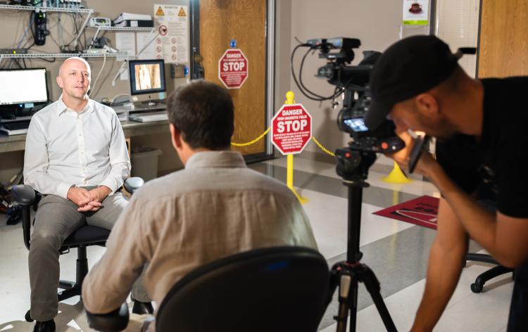 McKell Carter, assistant professor of psychology and neuroscience is interviewed and filmed by Quentin Domart, a French journalist directing the documentary.