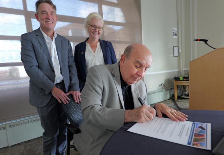 Patrick O’Rourke and Jessica Doty overlook Chancellor Phil DiStefano signing the Okanagan Charter