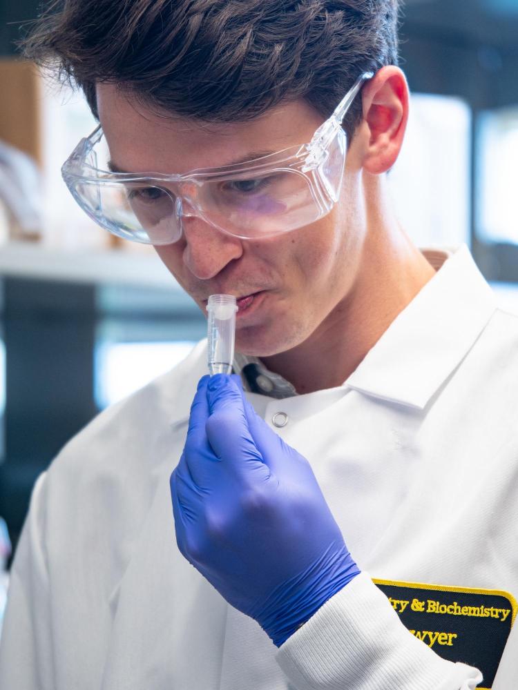 A lab technician spits in a tube