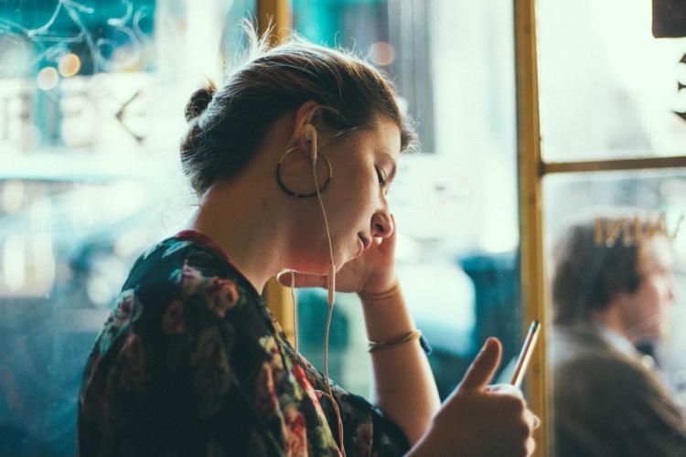 Person with earbuds and iphone