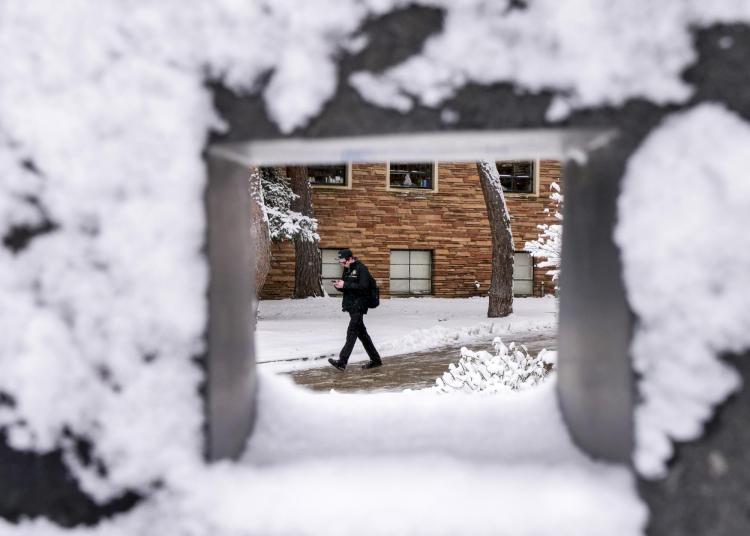 Person walks across snowy campus