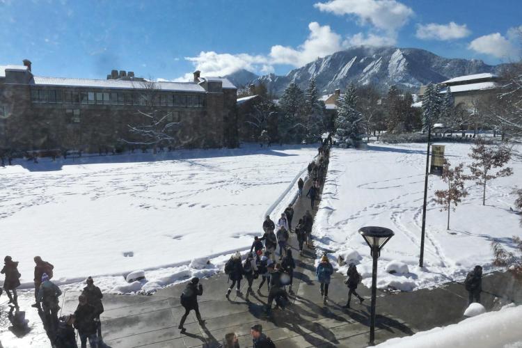 Students walk across a snowy campus