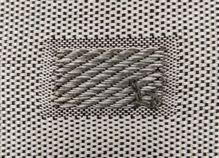 Patch of black-and-white woven fabric.