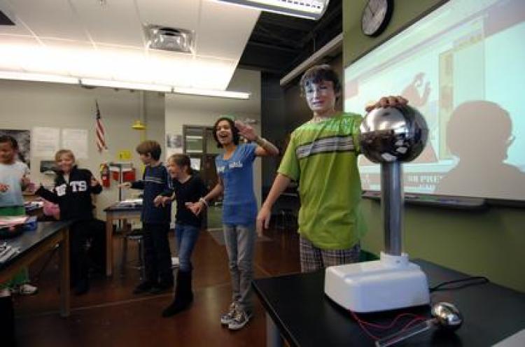 From right to left, sixth-graders Gerald Robinson, Carmen Houck, Gemma Truesdell, Wes Dolsen, Ellie Megerle and Livia Diener of Southern Hills Middle School in Boulder experiment with static electricity using a Van de Graaff generator and the "John Travoltage" PhET Interactive Simulation. (Photo by Patrick Campbell/University of Colorado)