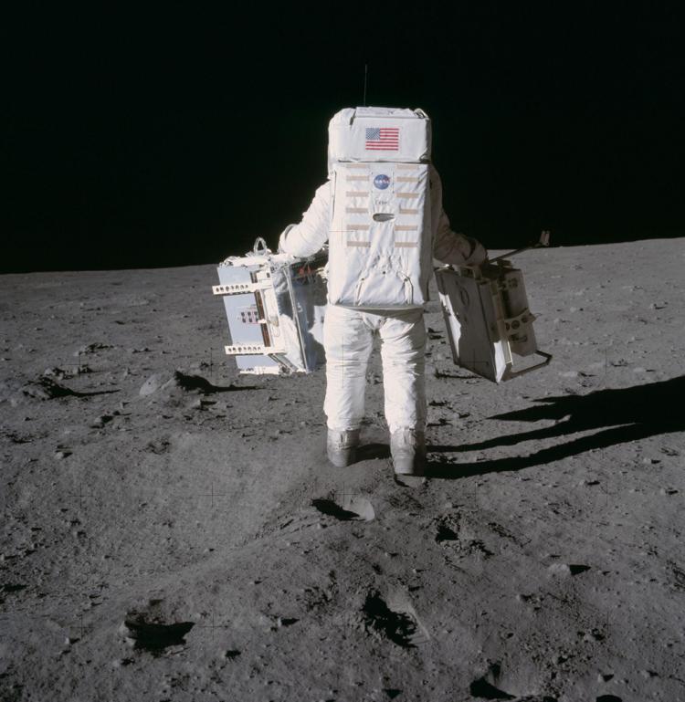 Buzz Aldrin carrying science experiments on the moon