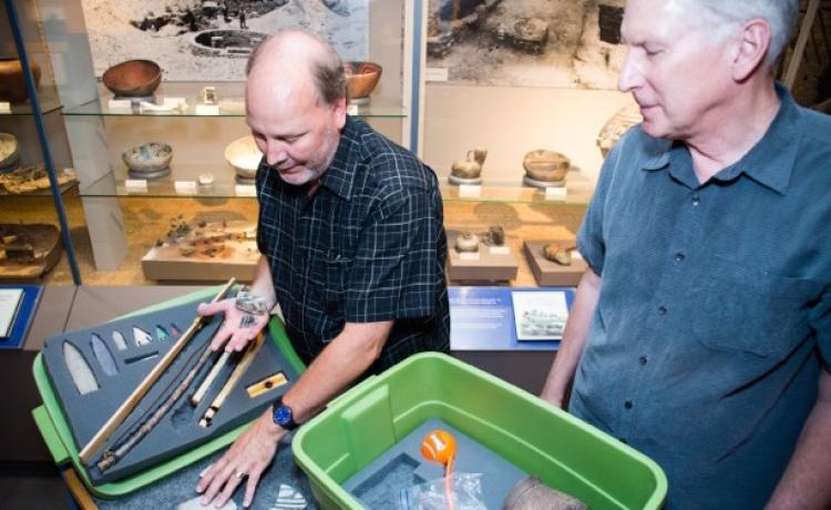 Senior museum educator Jim Hakala, left, and anthropology curator Steve Lekson prepare a fossil kit to be delivered to a Colorado classroom. 