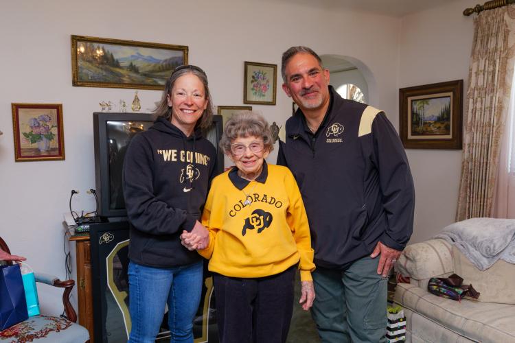 Gina LaFrazza, Peggy Coppom and Justin Schwartz stand and pose for a photo, taken in a living room.