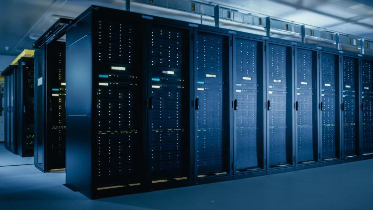 Racks of computer servers in rows of black cabinets in data center