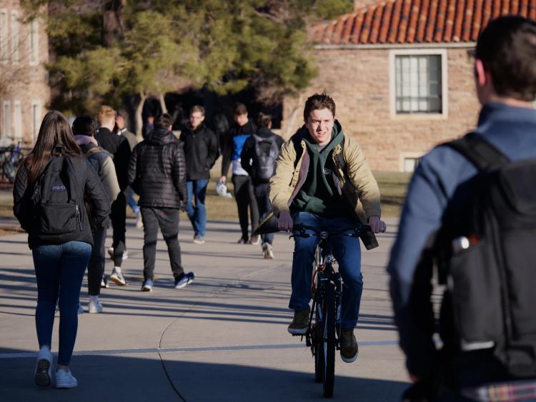 A student rides a bike on the CU Boulder campus on the first day of classes for spring 2020. (Photo by Casey A. Cass/University of Colorado)