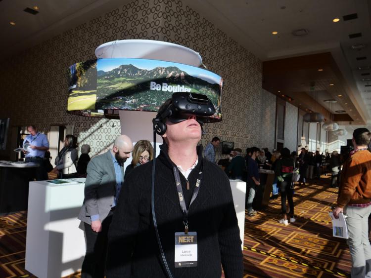Lance Markowitz tries on virtual reality goggles at the CMCI booth at CU Boulder Next. Photo by Glenn Asakawa.