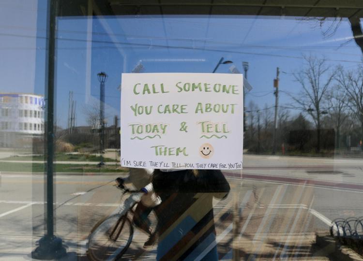 Handwritten sign in business window reads: 'Call someone you care about today & tell them.'